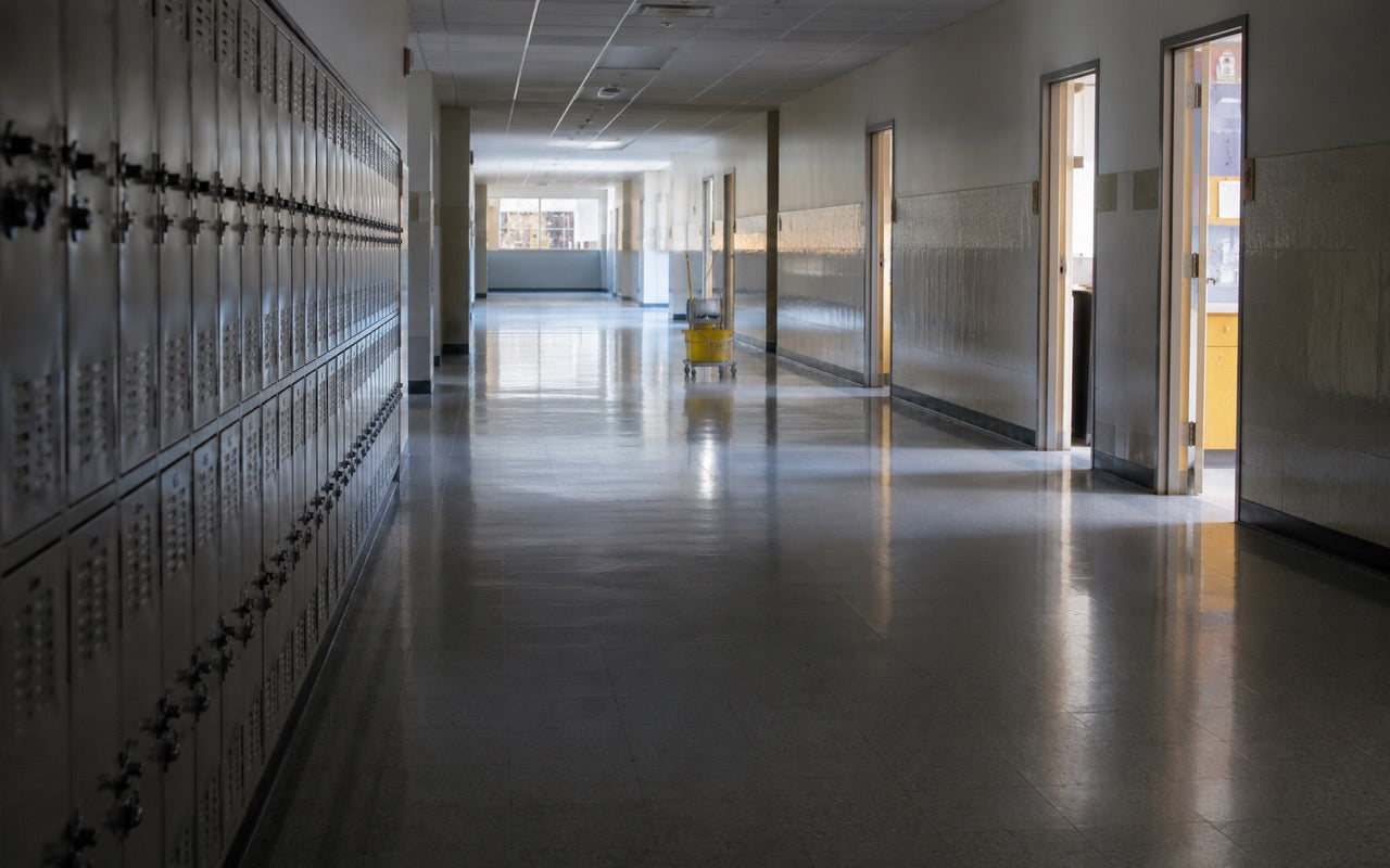 Empty school hallway with lockers and polished vinyl floor